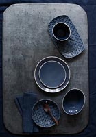Dark blue crockery on grey dining table