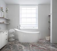 Freestanding bath in modern bathroom with marble floor 