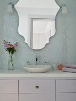 Sparkly mosaic tiling on wall behind sink unit in modern bathroom 