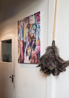 Colourful painting and feather duster in hallway 