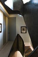 Curving black bannister around modern staircase 