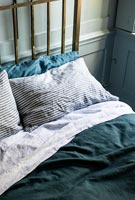 Striped pillow on brass frame bed 
