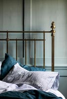 Striped pillow on brass frame bed 