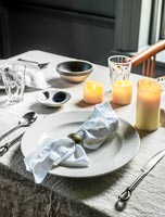 Candles and linen table cloth on dining table 