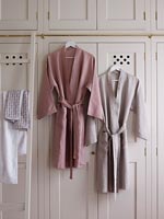 Linen dressing gowns hanging on wardrobe doors 
