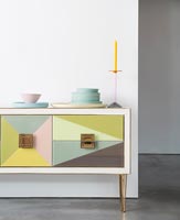 Colourful modern sideboard with pastel coloured plates 