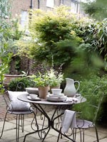 Small cafe style seating area in courtyard garden 