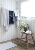Towels on washing line against wooden wall 
