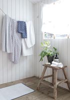 Towels on washing line against wooden wall 