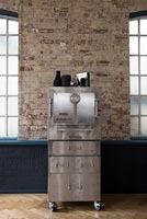 Industrial steel cabinet next to exposed brick wall 