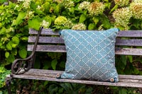 Patterned cushion on wooden bench 