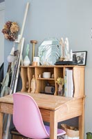 Wooden desk and pink plastic chair 