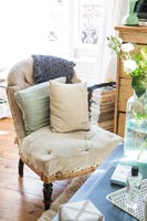 Uncovered upholstered chair with cushions in country living room 