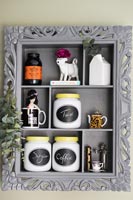 Grey painted shelving in carved frame in kitchen 