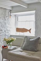 Wooden carving of whale on windowsill of white country living room