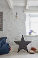 Modern black star light on floor of white country living room 