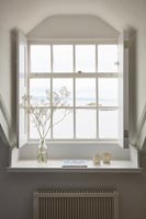 Sea view through windows with white shutters 