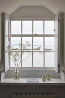 View of sea and boats through coastal cottage window 