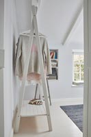 Wooden clothes rail in country bedroom 