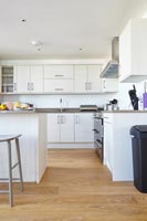 White modern kitchen with wooden floor