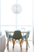 Turquoise chairs around dining table in modern white dining room 