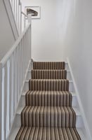 Brown stripy stair carpet on white staircase 