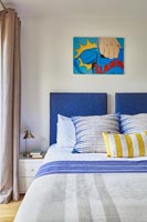 Colourful modern artwork on bedroom wall 