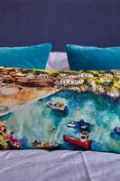 Coastal picture on cushion in modern bedroom 
