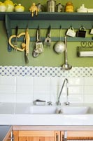Utensils on hooks above country kitchen sink