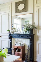 Fireplace with small vintage cabinet and black mantelpiece 