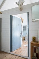 View through open wooden door to en-suite bathroom from modern country bedroom