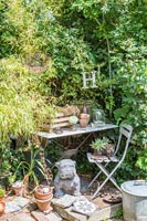 Dog statue next to small garden table in garden 