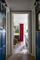 Blue painted hallway walls with view into dining room 
