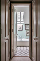 Country bathroom with pale blue painted walls and patterned floor 