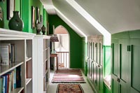Bookshelves in green and white corridor 