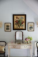 Floral painting above dressing table in country bedroom 