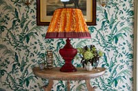 Large orange lamp on wooden console table in hallway 