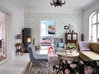 Spotty feature wall in eclectic living room with log burning stove 