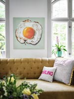 Painting of a fried egg on wall of modern living room 