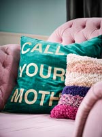 Colourful cushions on pink sofa 