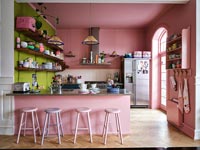 Modern kitchen with pink painted walls and parquet flooring 