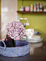 Pink hydrangea flower in vase in purple basket 