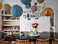 Modern dining room with variety of paper lantern spheres over table 