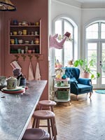 Modern kitchen with pink painted walls and parquet flooring 