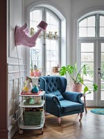 Pink rhino lamp over drinks trolley and blue armchair 