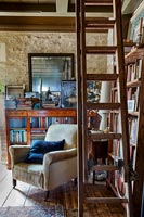 Armchair in corner of living room surrounded by bookshelves 