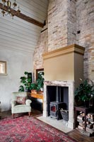 Country living room with lit wood burning stove 