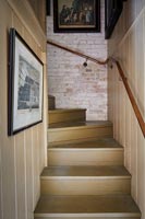 Painted wooden staircase with exposed brick walls 