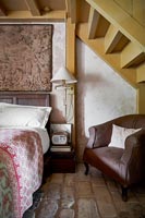 Country bedroom with exposed staircase 