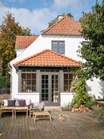 Country house exterior with pet dog and garden furniture on terrace 